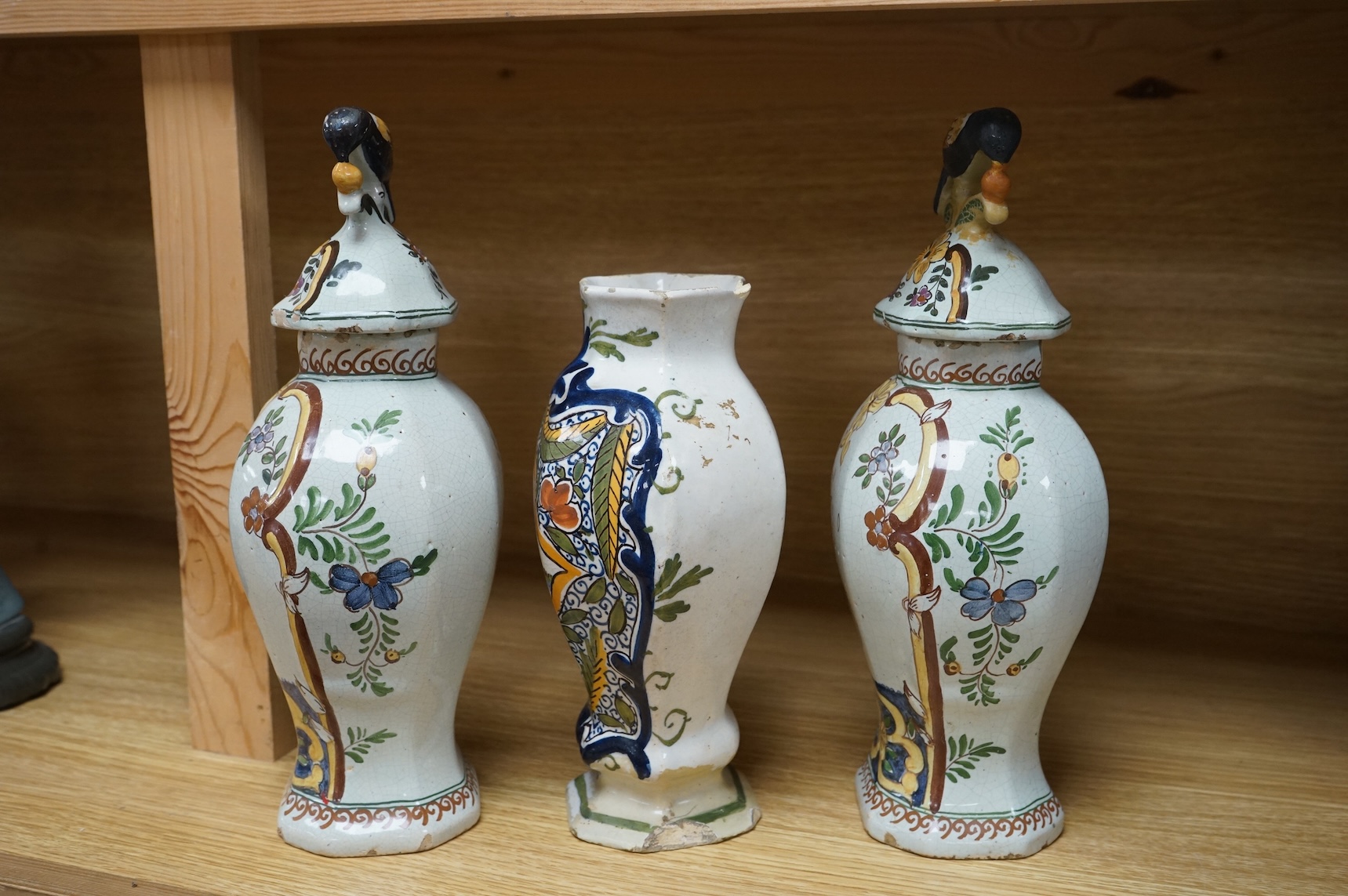 Three 18th/19th century Delft vases, the pair decorated with portraits of king and queen, H 30cm x W 15 (with lids), H 23cm x W 15 (without lid)